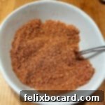 A small bowl filled with sweet dry rub seasoning, ready to be applied to meat.