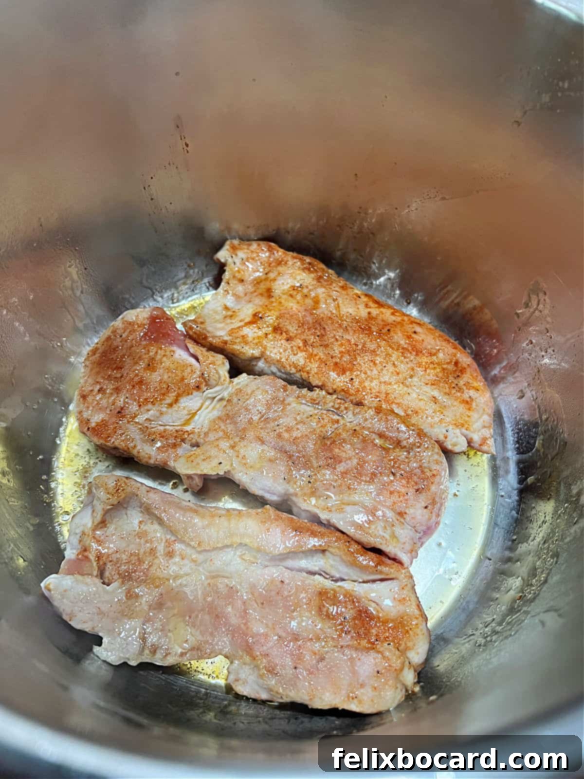 Strips of country-style pork ribs searing and browning in the Instant Pot on the sauté function.