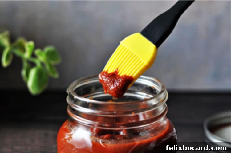 Keto Grill Master Sauce 2 Yellow basting brush containing keto BBQ sauce dipped from the jar