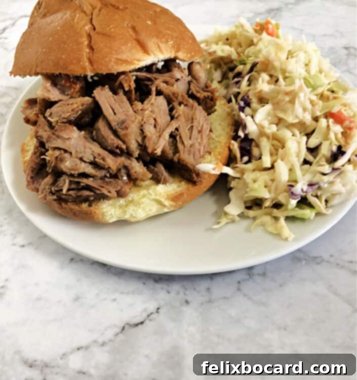 pulled pork sandwich with coleslaw on a small white plate