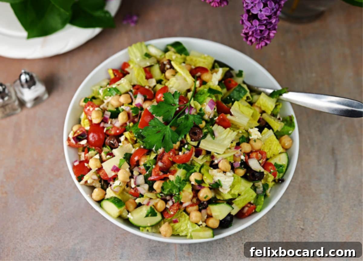 A beautifully presented bowl of Mediterranean chopped salad, brimming with colorful vegetables, ready to be served and enjoyed.