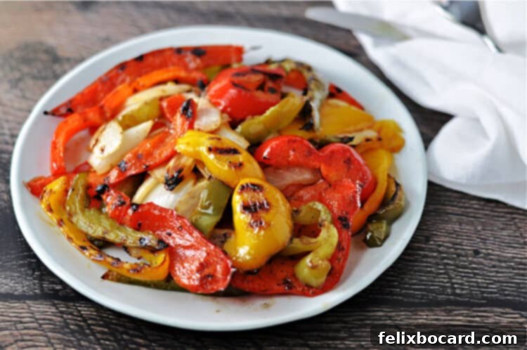 Sweet and Smoky Grilled Peppers and Onions 2 Grilled bell peppers and onions arranged appealingly on a white plate, showcasing their vibrant colors and smoky char marks.