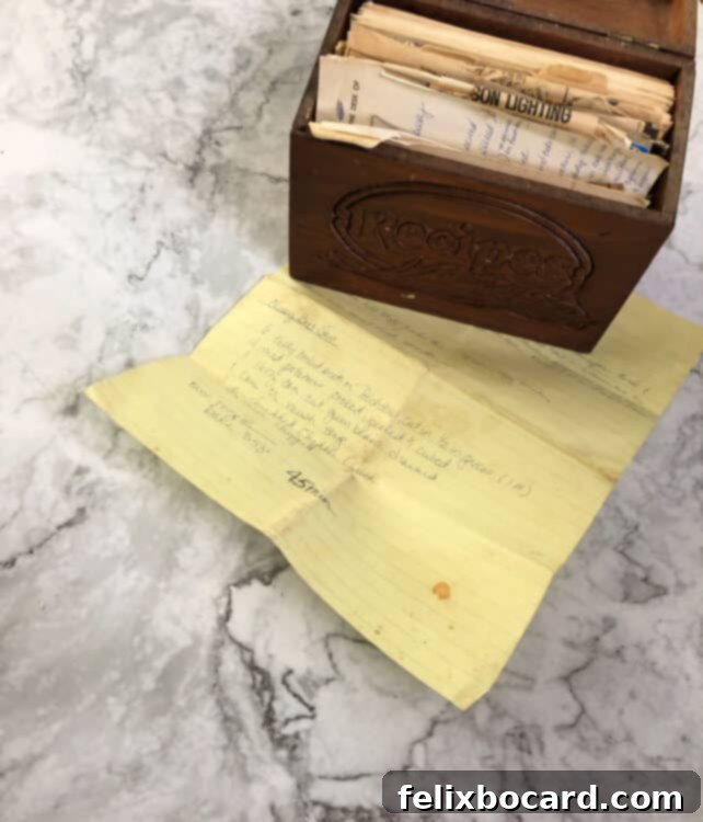 An old recipe box containing a yellow piece of legal paper with a handwritten recipe for brat stew.
