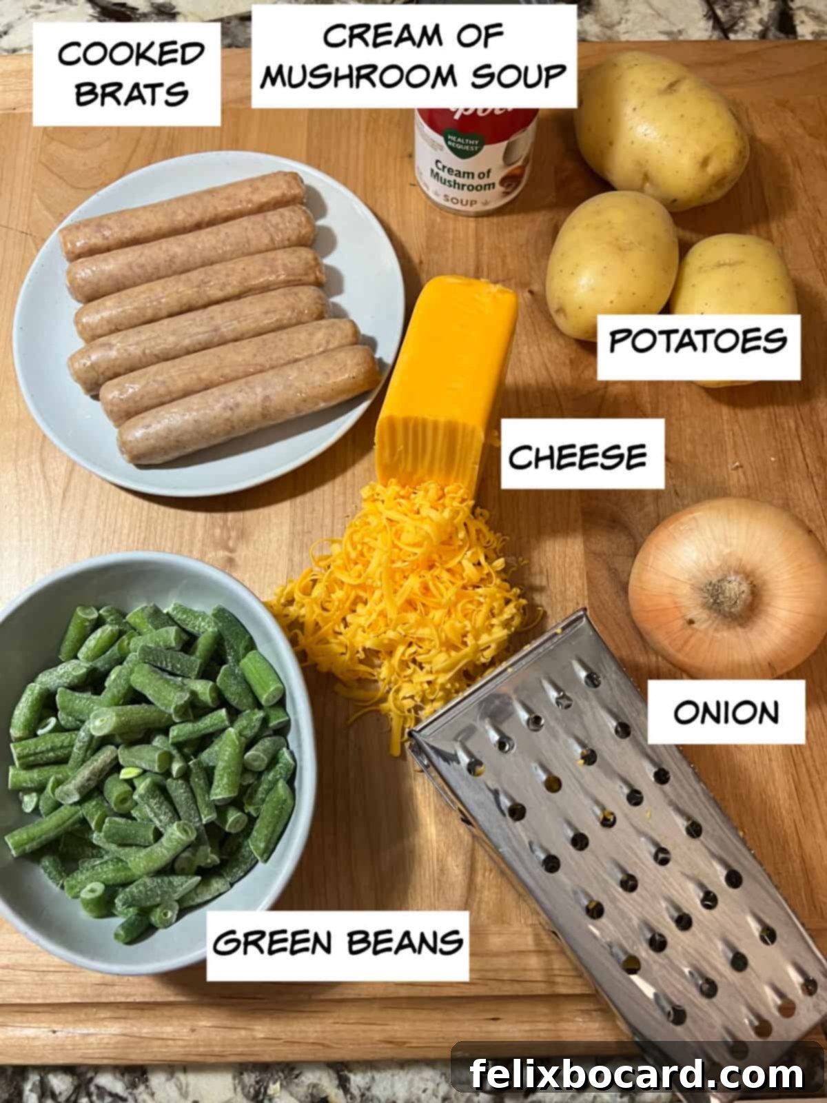 A selection of fresh ingredients laid out on a counter, including cooked bratwursts, a can of cream of mushroom soup, whole potatoes, a block of cheese, an onion, and fresh green beans. These are the core components for the Cheesy Bratwurst Casserole.