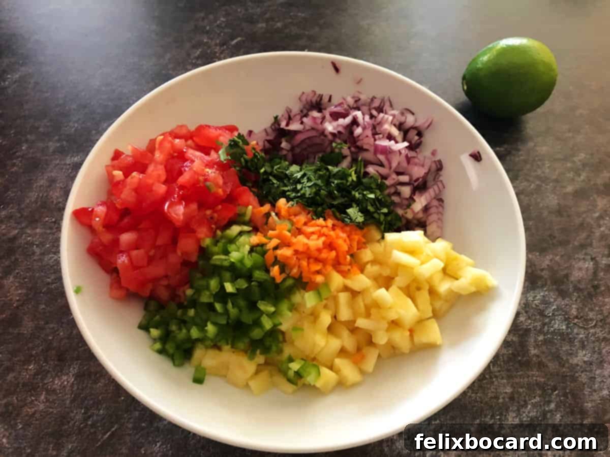 Tropical Heat Salsa 4 Bowl filled with freshly chopped pineapple, tomatoes, habanero peppers, jalapeno peppers, red onion, and cilantro, ready to be mixed for salsa.