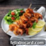 Grilled Cajun Shrimp on a plate with a small green salad and some lemon slices