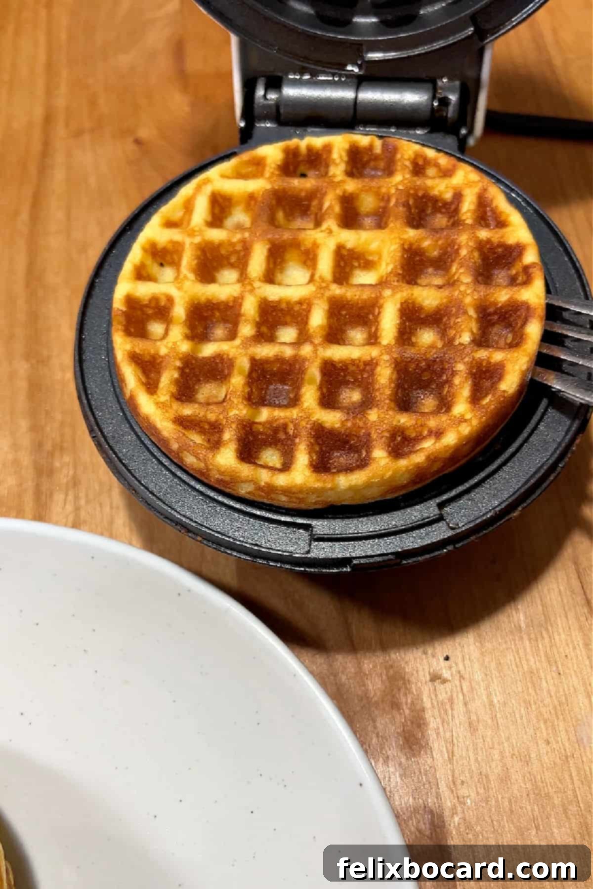 breakfast chaffle ready to remove from waffle iron.