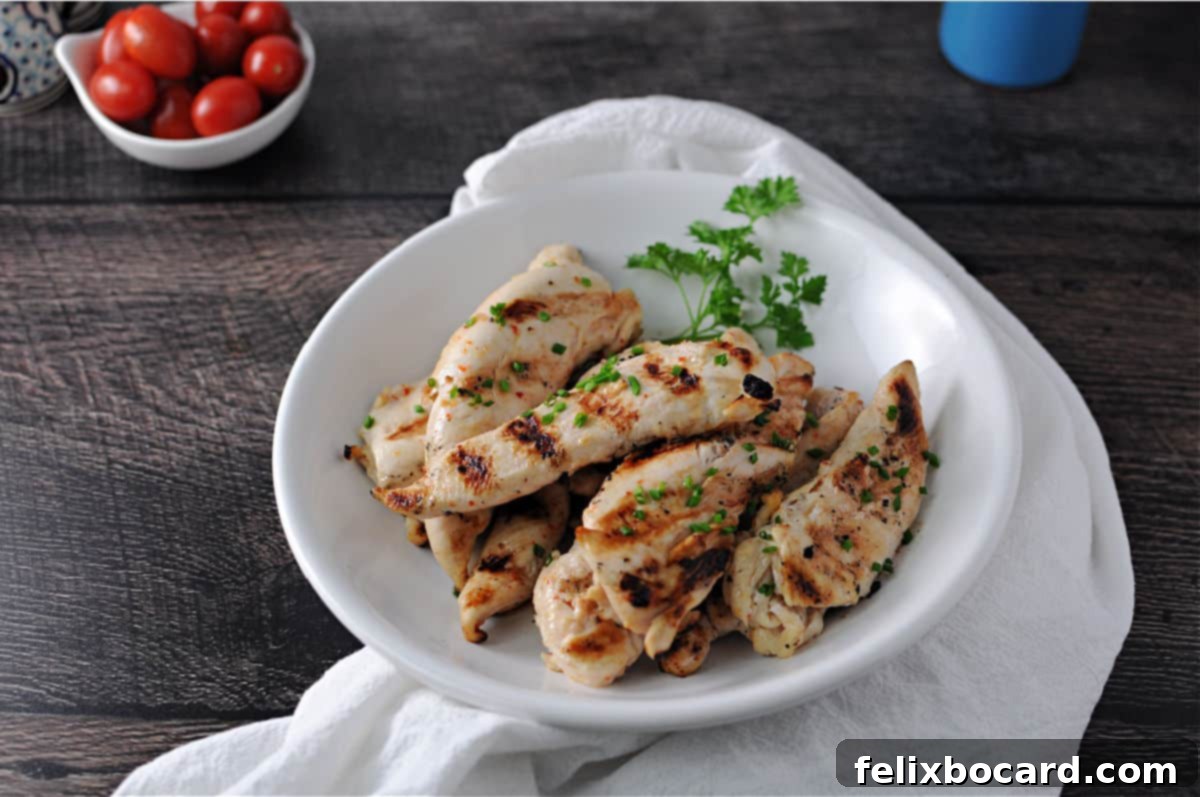 Chargrilled Chicken Strips 6 A close-up of perfectly cooked chicken tenderloin strips, golden-brown and juicy, served in a white ceramic bowl.