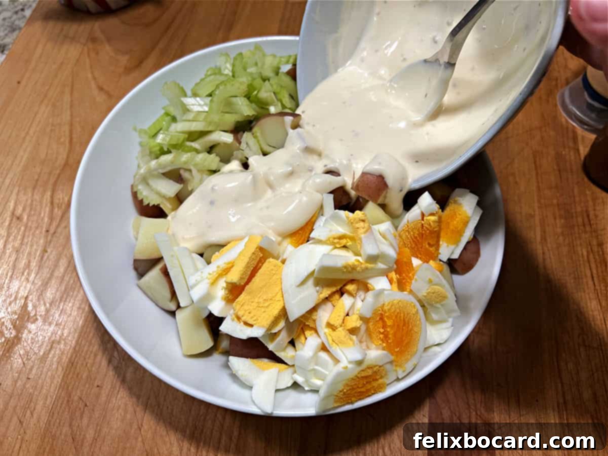 Creamy Red Potato Salad 9 Adding dressing to the bowl.