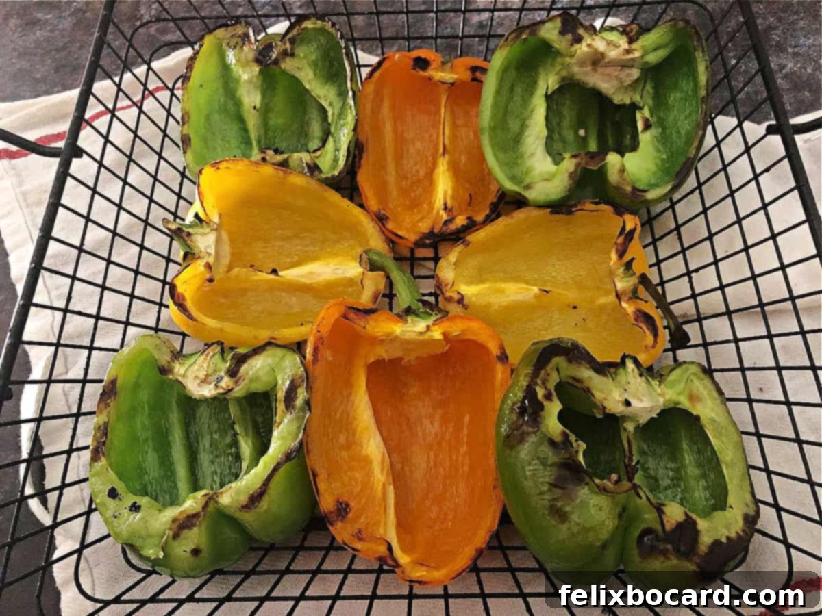 Charred bell pepper halves ready for stuffing, resting in a grill basket on a wooden surface