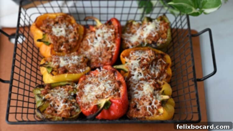 Close-up of grilled stuffed peppers, topped with melted cheese, arranged in a grill basket on a hot grill