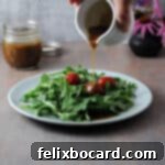 Elevate Your Salad with Homemade Balsamic Vinaigrette 11 small pitcher pouring balsamic vinaigrette onto a plate of salad greens