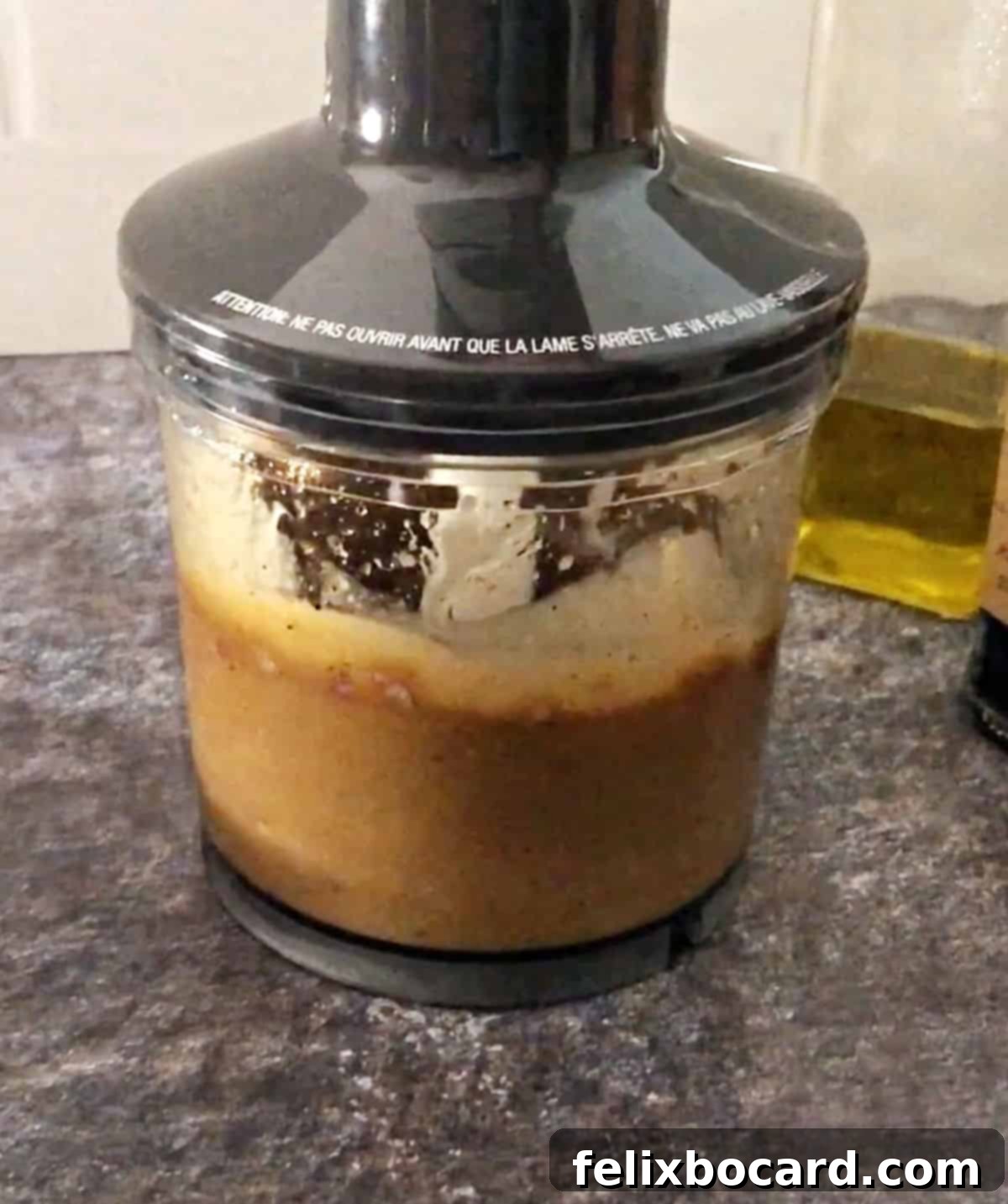 Elevate Your Salad with Homemade Balsamic Vinaigrette 6 Ingredients for balsamic vinaigrette, including liquids and aromatics, actively blending inside a small food processor or blender cup.