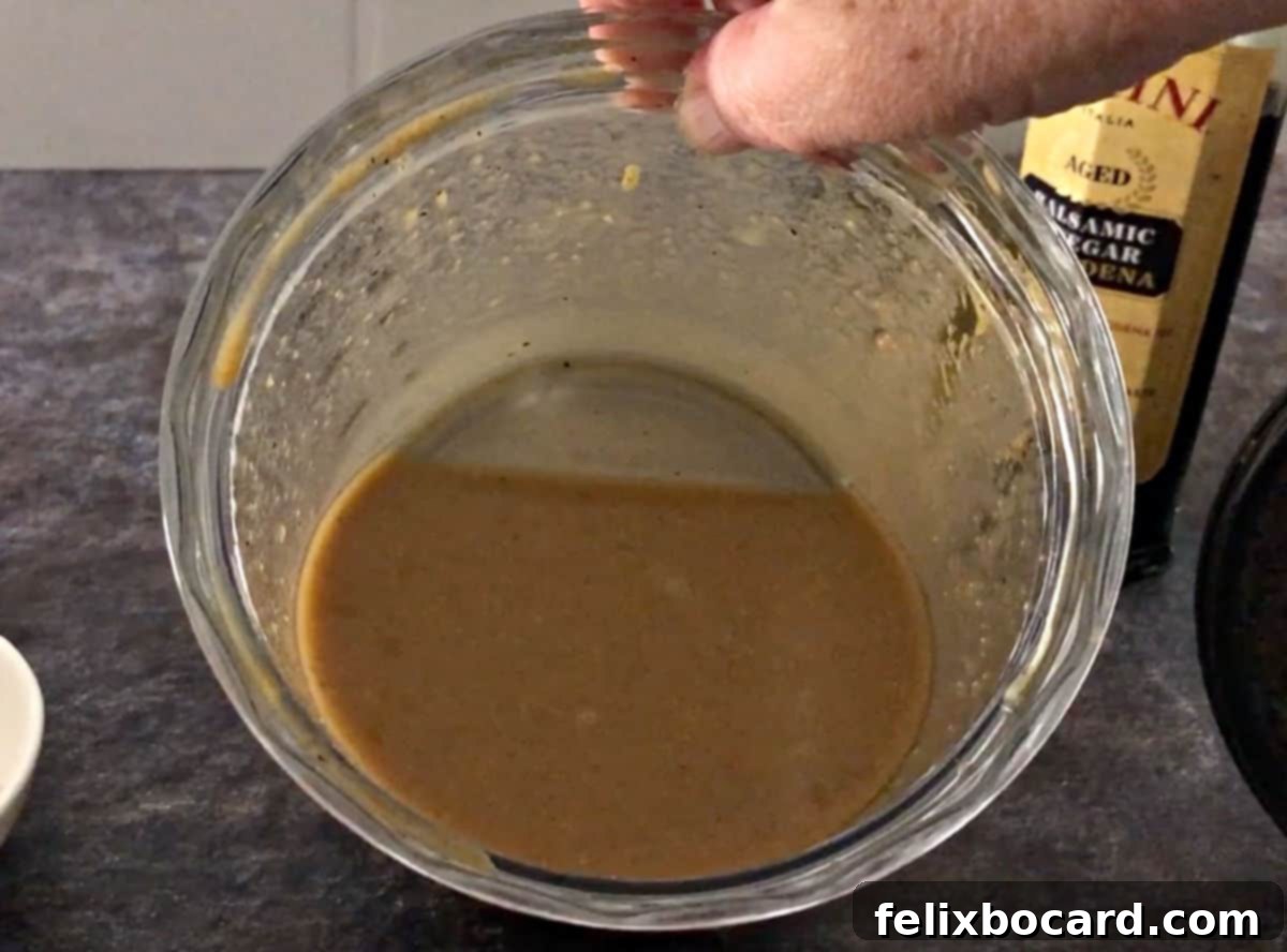 Elevate Your Salad with Homemade Balsamic Vinaigrette 7 Smooth, blended balsamic vinaigrette dressing, light brown in color, sitting in a small blender cup, ready to be poured into a storage jar.