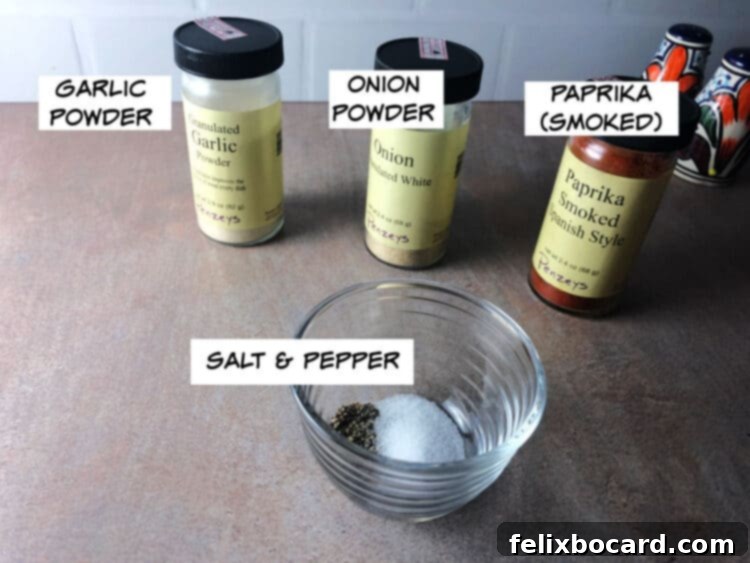 Ingredients for a simple dry rub: paprika, garlic powder, onion powder, salt, and black pepper displayed in small bowls