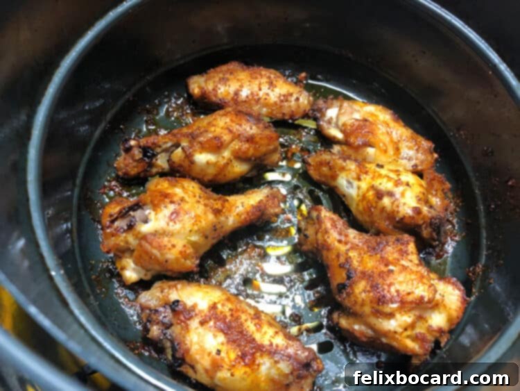 BBQ chicken wings in an Instant Pot air fryer basket, showing crispy skin