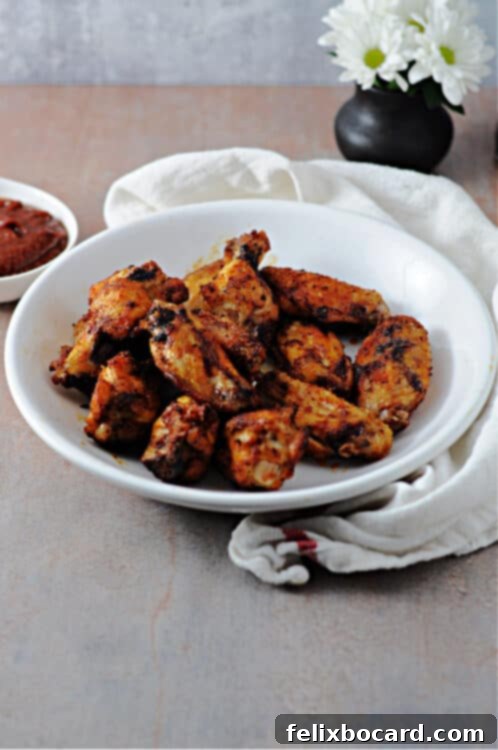 Air fried wings artfully arranged in a serving bowl, with a small vase of flowers in the background