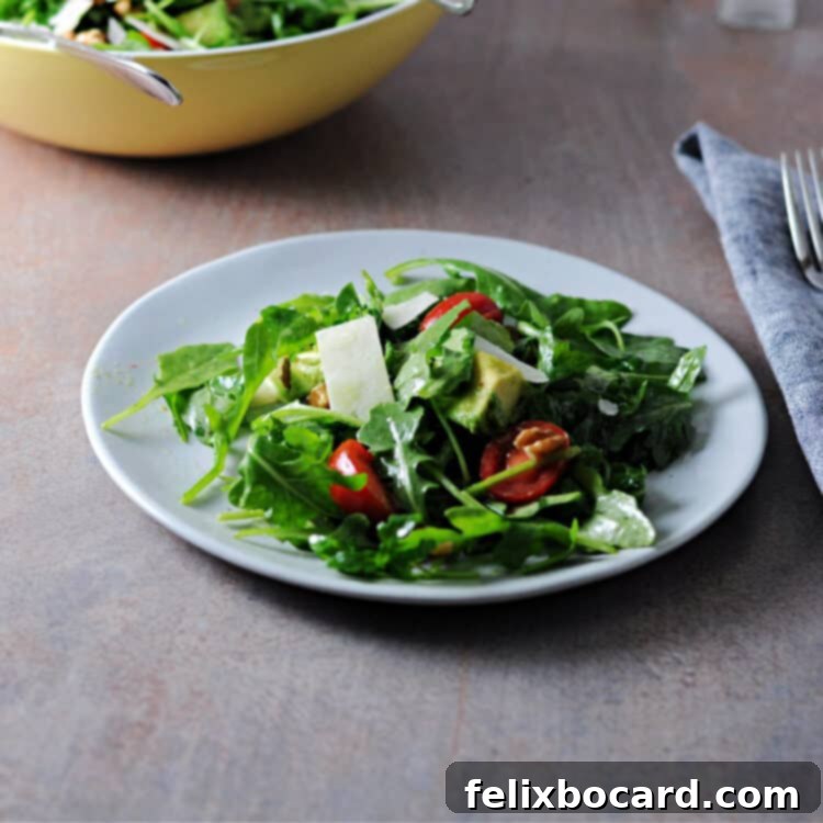 Fresh Arugula Avocado Salad on a small white plate, ready to be served.
