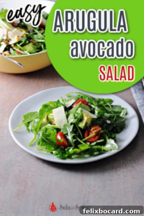 Pinterest Pin image for Arugula Avocado Salad, showing a close-up of the salad with text overlay.