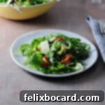 Fresh Arugula Avocado Salad on a small white plate, ready to be served.