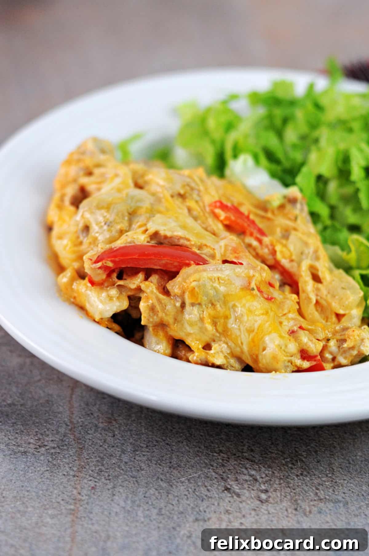 a bowl with a serving of chicken fajita casserole, plus some salad.