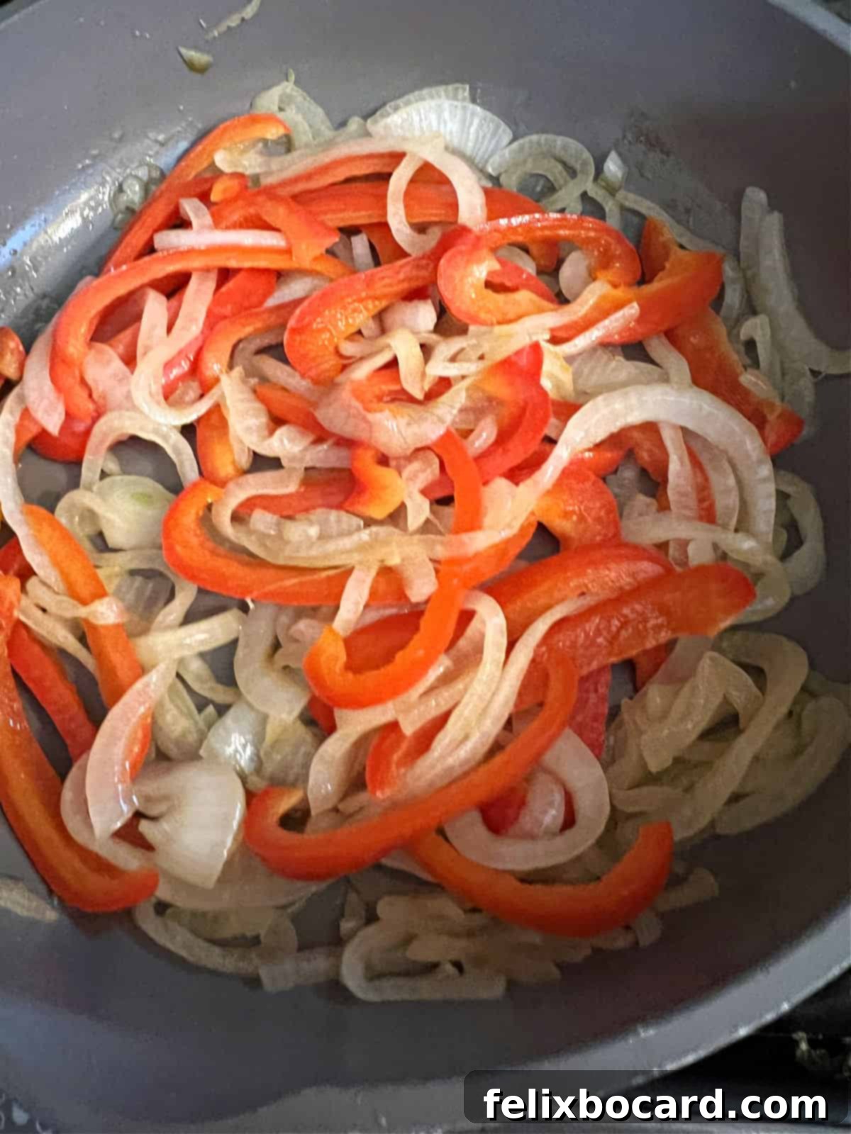 pepper and onion cooking in a skillet.