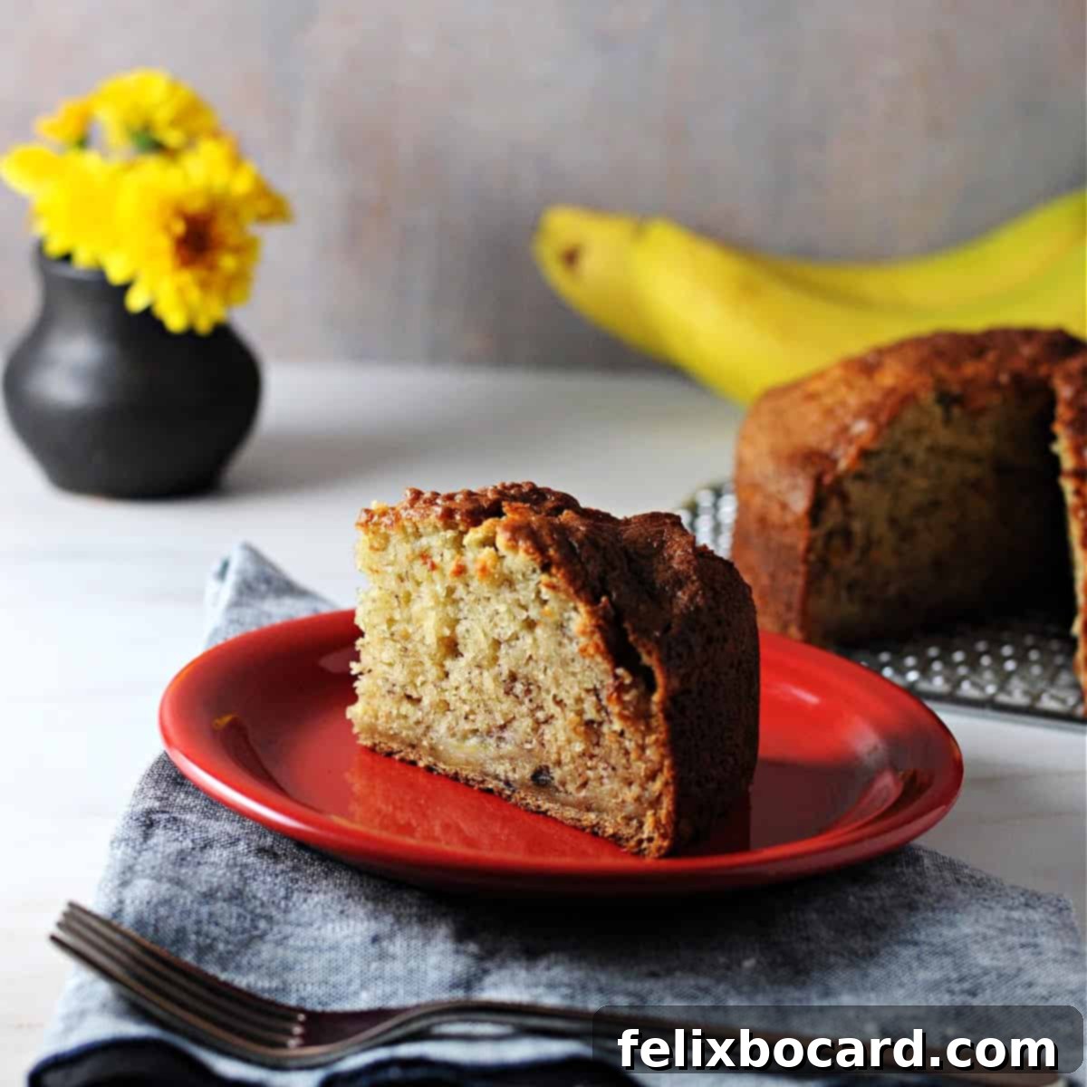 Golden Air Fryer Banana Bread 2 A perfectly baked slice of air fryer banana bread on a small red plate, ready to be enjoyed.