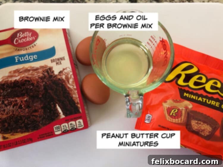 Essential ingredients laid out: a box of brownie mix, eggs, vegetable oil, and miniature peanut butter cups.
