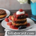 cake mix waffles stacked and topped with berry sauce and whipped cream
