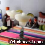 Two frozen margaritas in classic margarita glasses, garnished with lime, ready to be served.