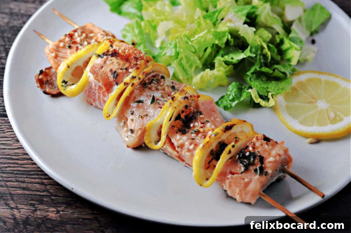 A freshly grilled salmon kabob, served elegantly on a plate alongside a vibrant green salad, showcasing the golden-brown salmon pieces and charred lemon slices.