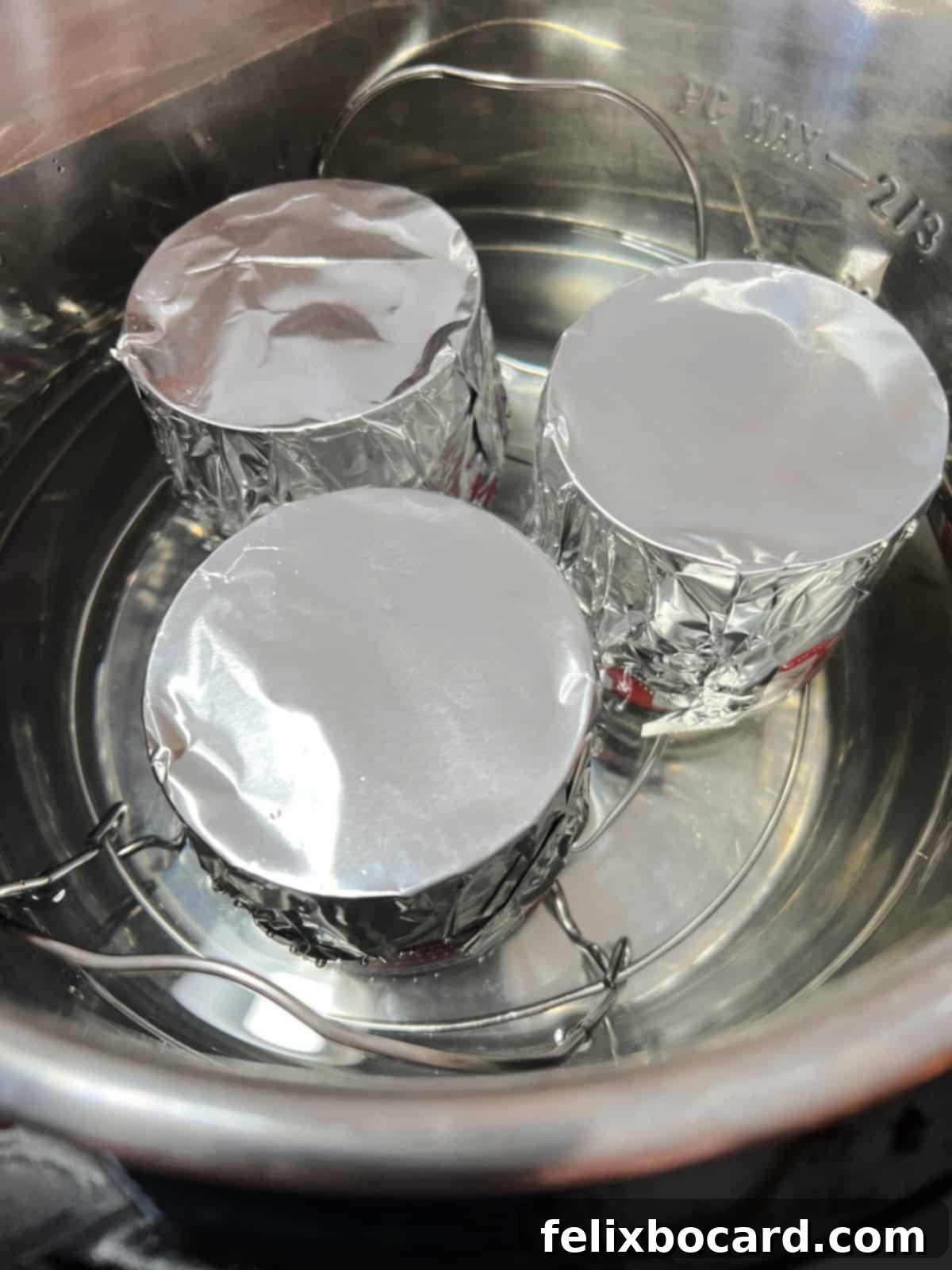 Instant Pot Dulce de Leche 5 Three cans of sweetened condensed milk covered in foil, ready to be cooked in an Instant Pot.