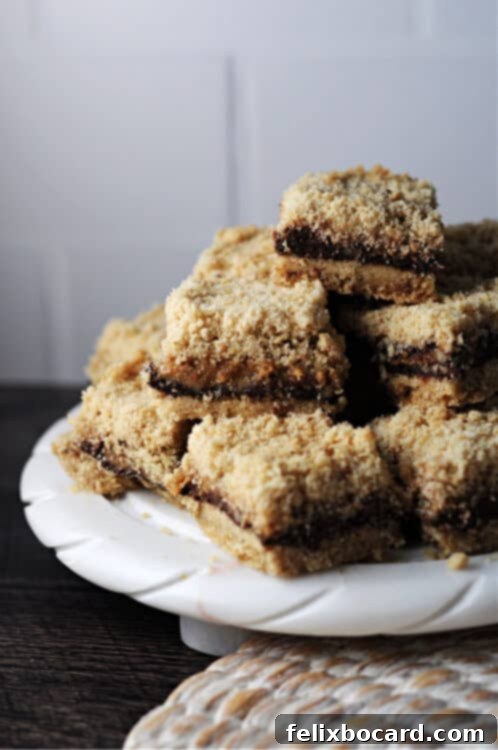 A stack of golden brown chocolate caramel pecan bars on a small, elegant plate