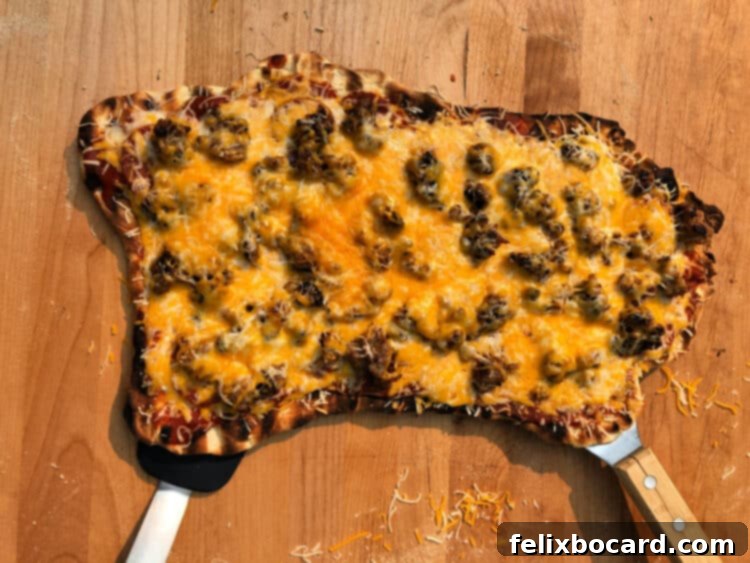 Appetizing grilled pizza loaded with cooked Italian sausage and pepperoni slices, a true meat lover's delight.