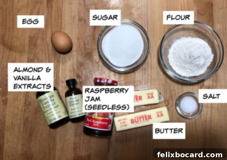 A flat lay image displaying the ingredients needed for vampire kiss cookies: egg, sugar, flour, salt, softened butter, seedless raspberry jam, and small bottles of almond and vanilla extracts.
