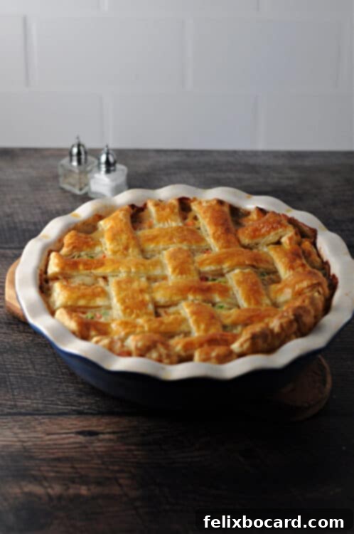 Puff Pastry Turkey Pot Pie with a golden lattice top crust, still in the pie plate, ready to be served.