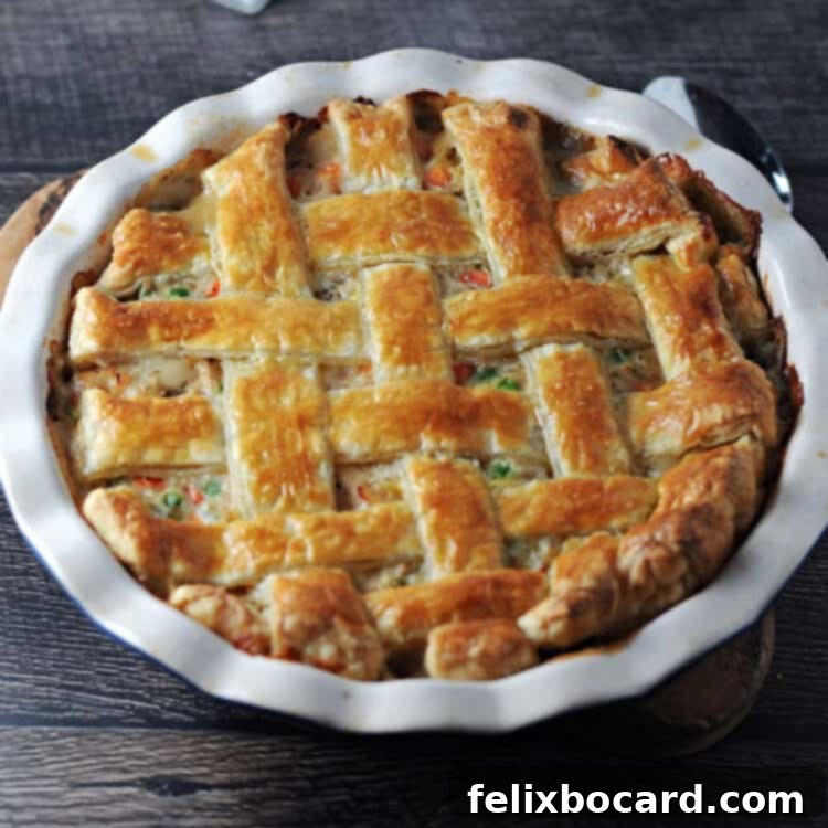 A perfectly baked puff pastry turkey pot pie with a golden lattice crust, still warm in its pie plate.
