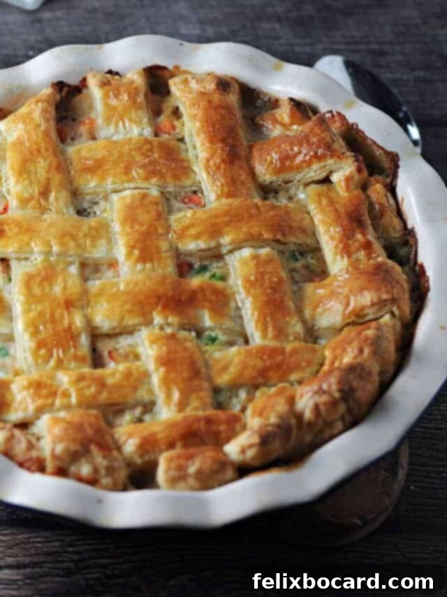 A rustic shot of a puff pastry turkey pot pie in a pie plate.