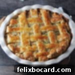 A baked puff pastry turkey pot pie with a golden lattice crust in a pie plate.