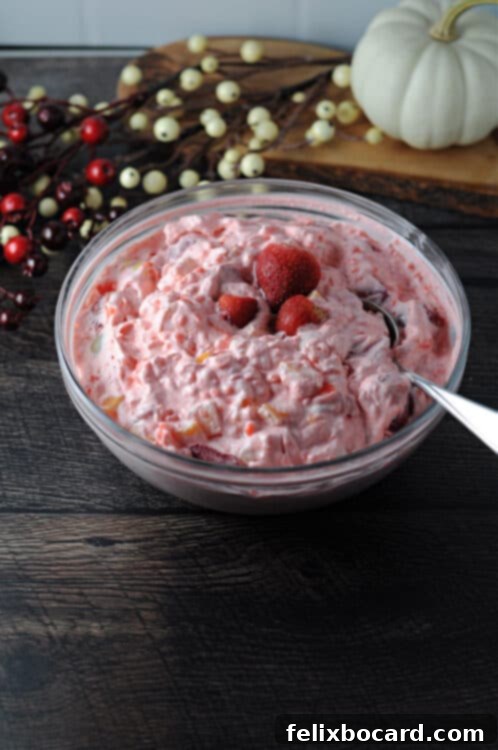 Vibrant and creamy tapioca fruit salad in a clear serving bowl, garnished with fresh berries