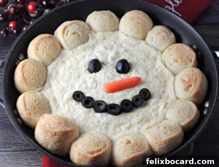 Close-up of baked snowman dip in a skillet, showcasing the bread ring and creamy dip texture