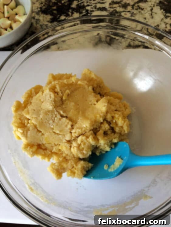 Delicate Sugar Blooms 4 Sugar cookie dough being mixed in a bowl, showing a smooth and cohesive texture.