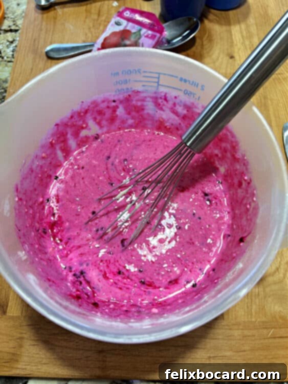 A bowl of bright pink pancake batter, showcasing the stunning, natural color infused by dragon fruit