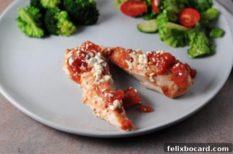 Mediterranean Feta Chicken Tenders 2 Two succulent baked feta chicken tenderloins elegantly plated, garnished with fresh herbs, ready to be enjoyed.