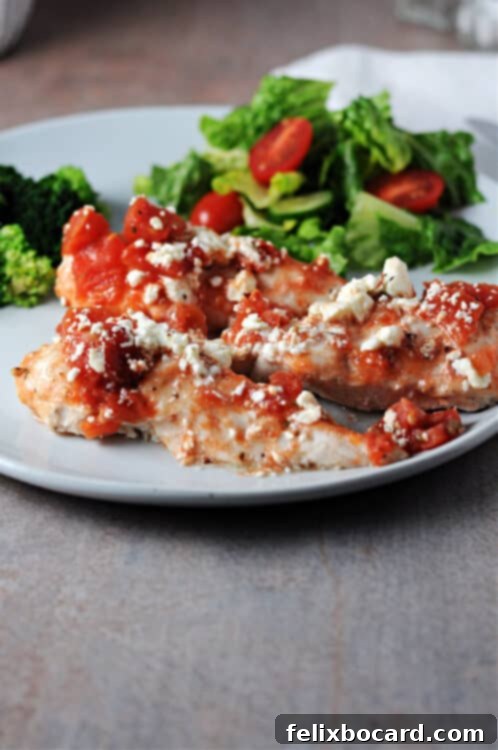 Mediterranean Feta Chicken Tenders 7 A serving of baked feta chicken tenderloins on a plate, accompanied by a fresh green salad and steamed broccoli.