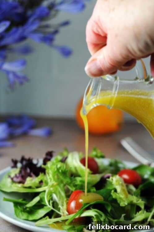 meyer lemon vinaigrette pouring onto a small salad