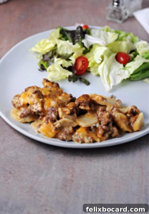 hamburger potato casserole on a plate with green salad