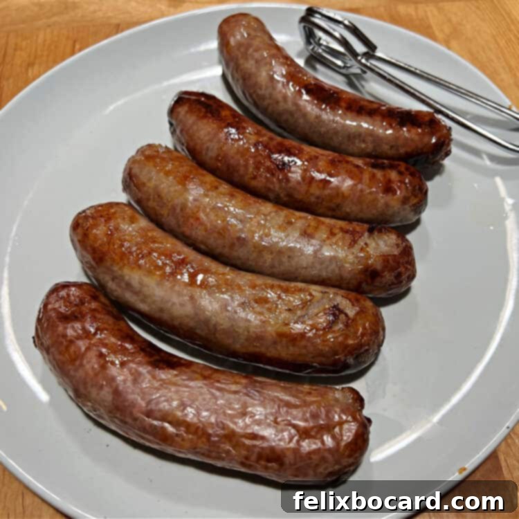 Five perfectly cooked air fryer brats arranged on a white plate, ready to be served.