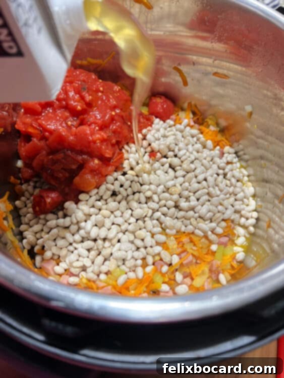 Hearty Instant Pot Ham and Navy Bean Soup 5 add beans, tomatoes and chicken broth.