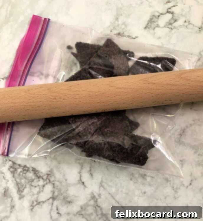 rolling pin crushing blue tortilla chips in a bag